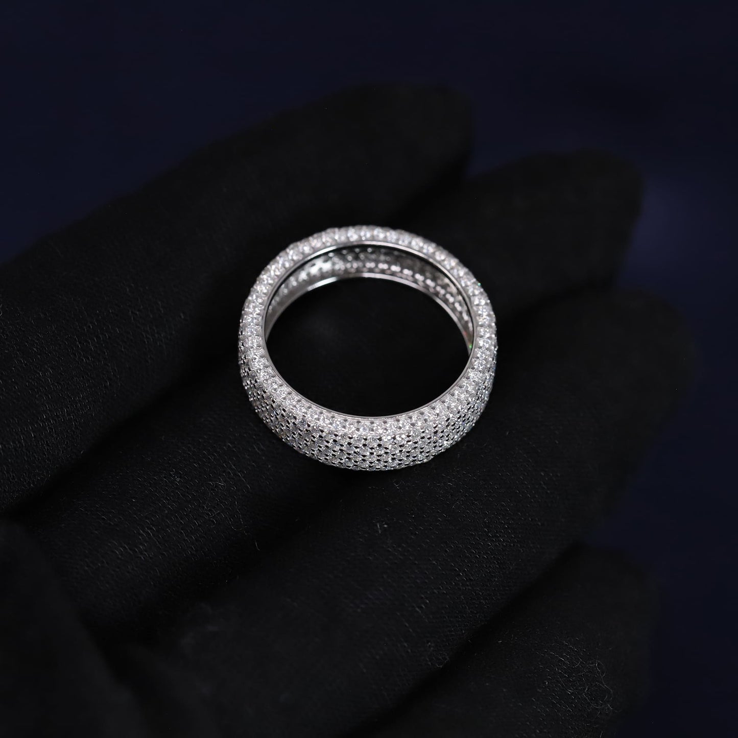 Silver ring with small stones on a black fabric background
