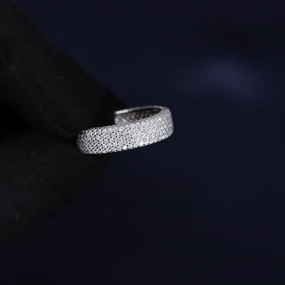 Silver ring with embedded stones on a dark background