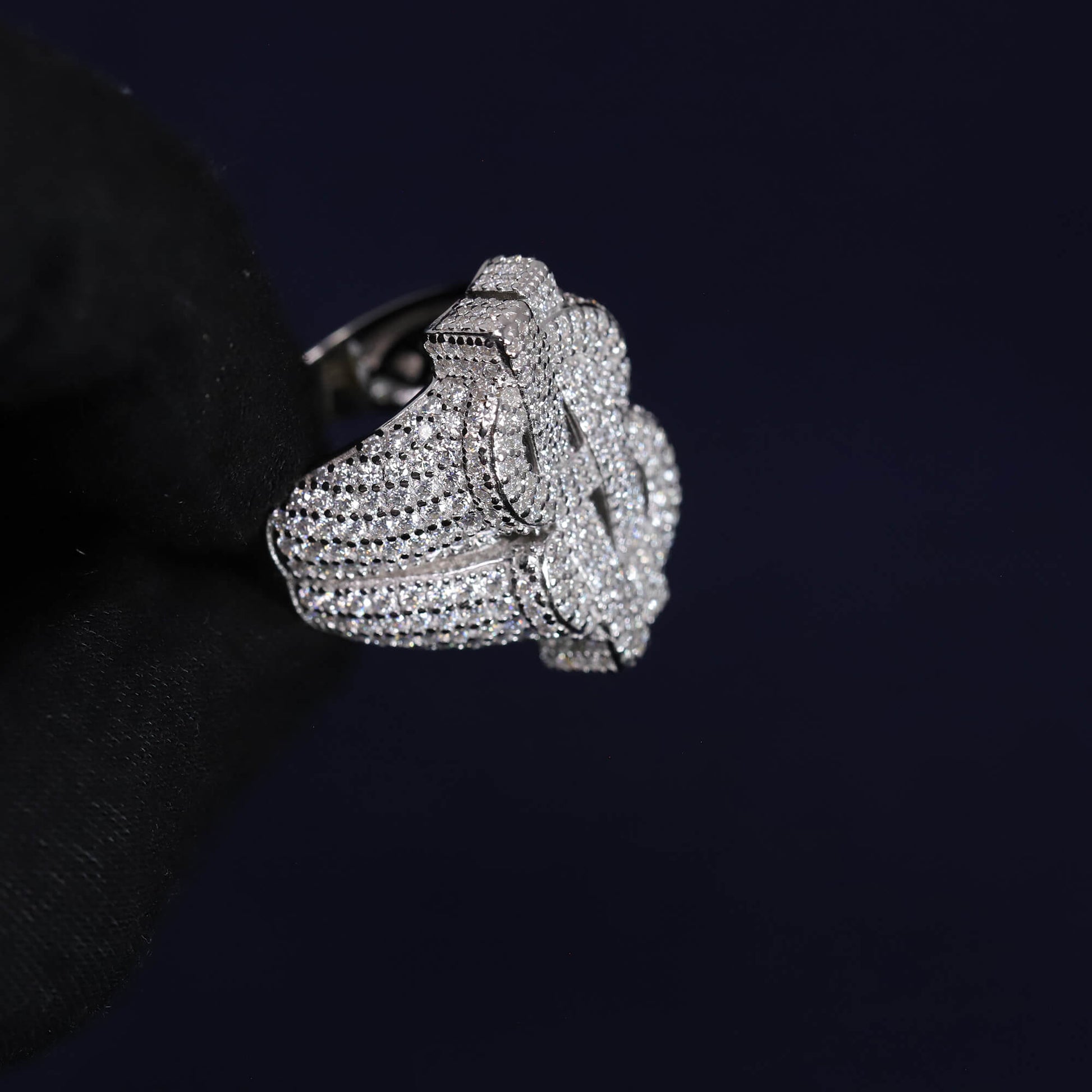 Silver rose-shaped ring with gemstones on a black background