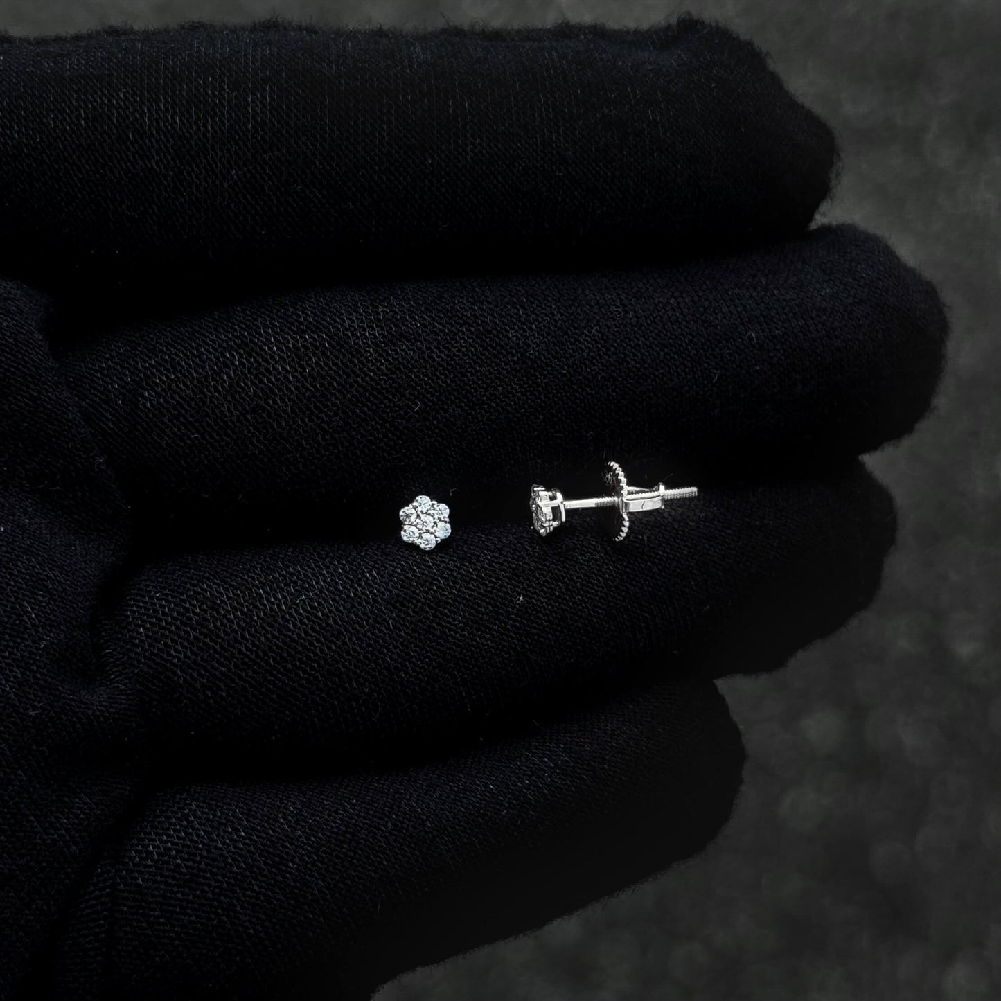 Sterling silver moissanite cluster earring and screw-back post shown on black glove.
