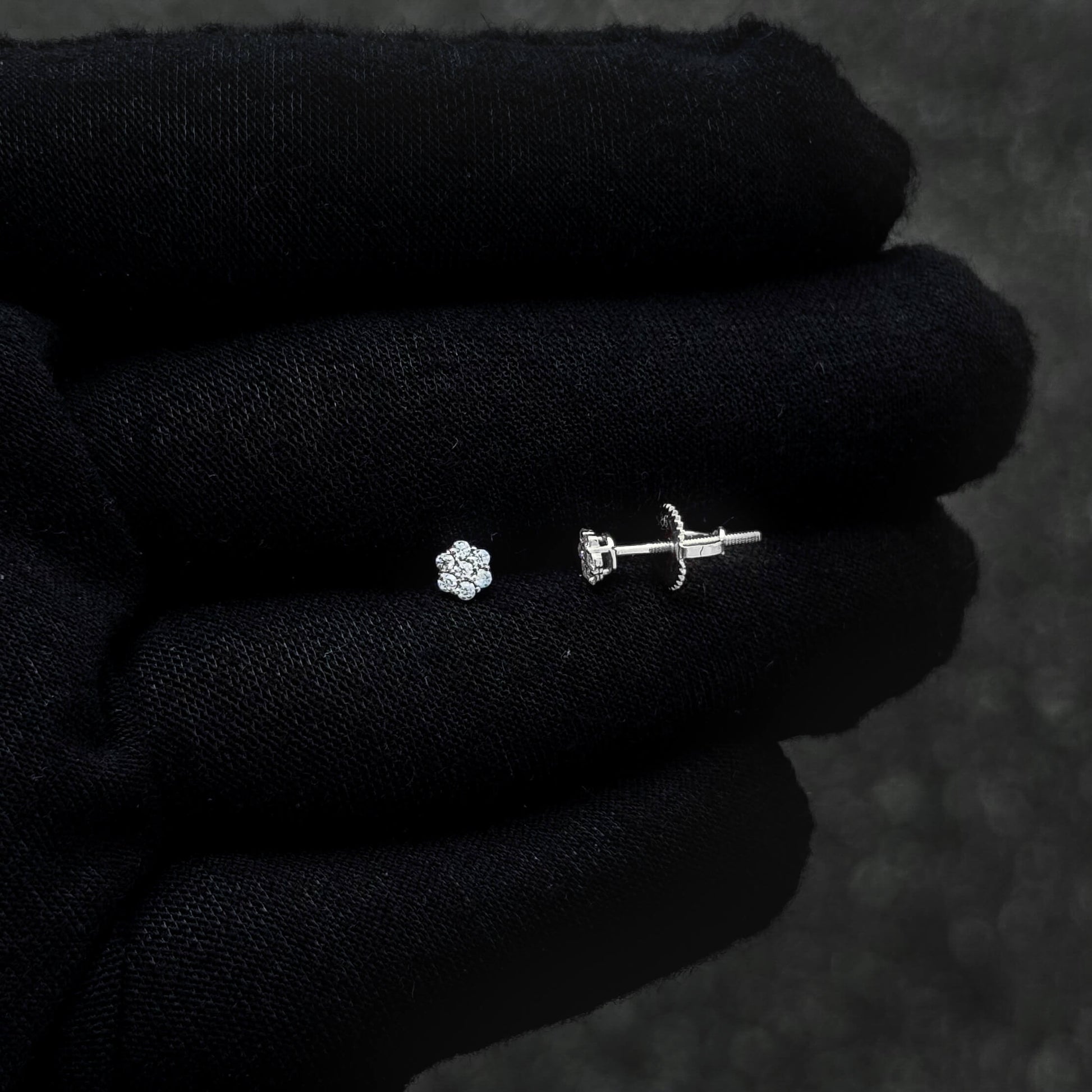 Sterling silver moissanite cluster earring and screw-back post shown on black glove.