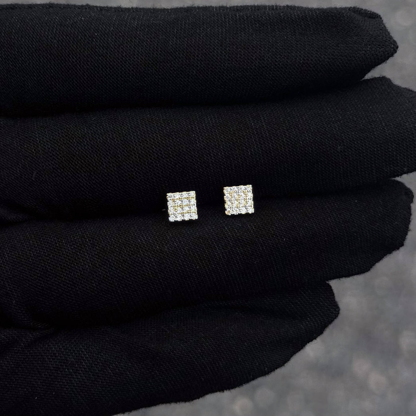 Small 5mm square Moissanite cluster diamond stud earrings in sterling silver displayed on glove.