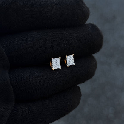 Gold-accent 6mm square Moissanite cluster earrings displayed at an angled view on black glove.