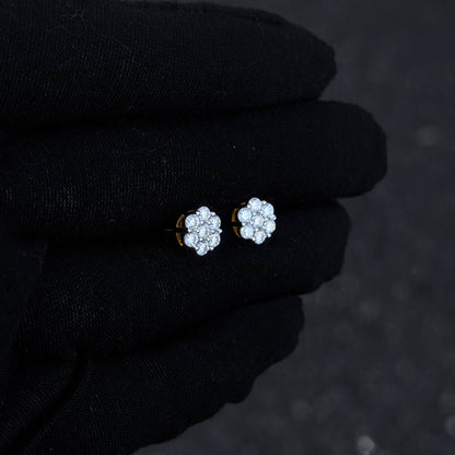 Small floral moissanite cluster earrings shown on black glove with warm silver detailing.