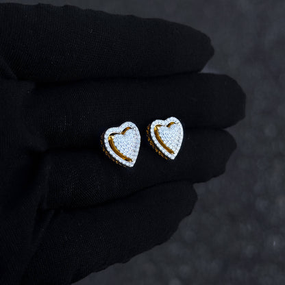 Gold heart moissanite cluster stud earrings shown on black glove with pavé detailing.