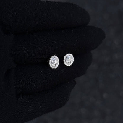 Round Moissanite cluster earrings in sterling silver displayed on black glove for scale.