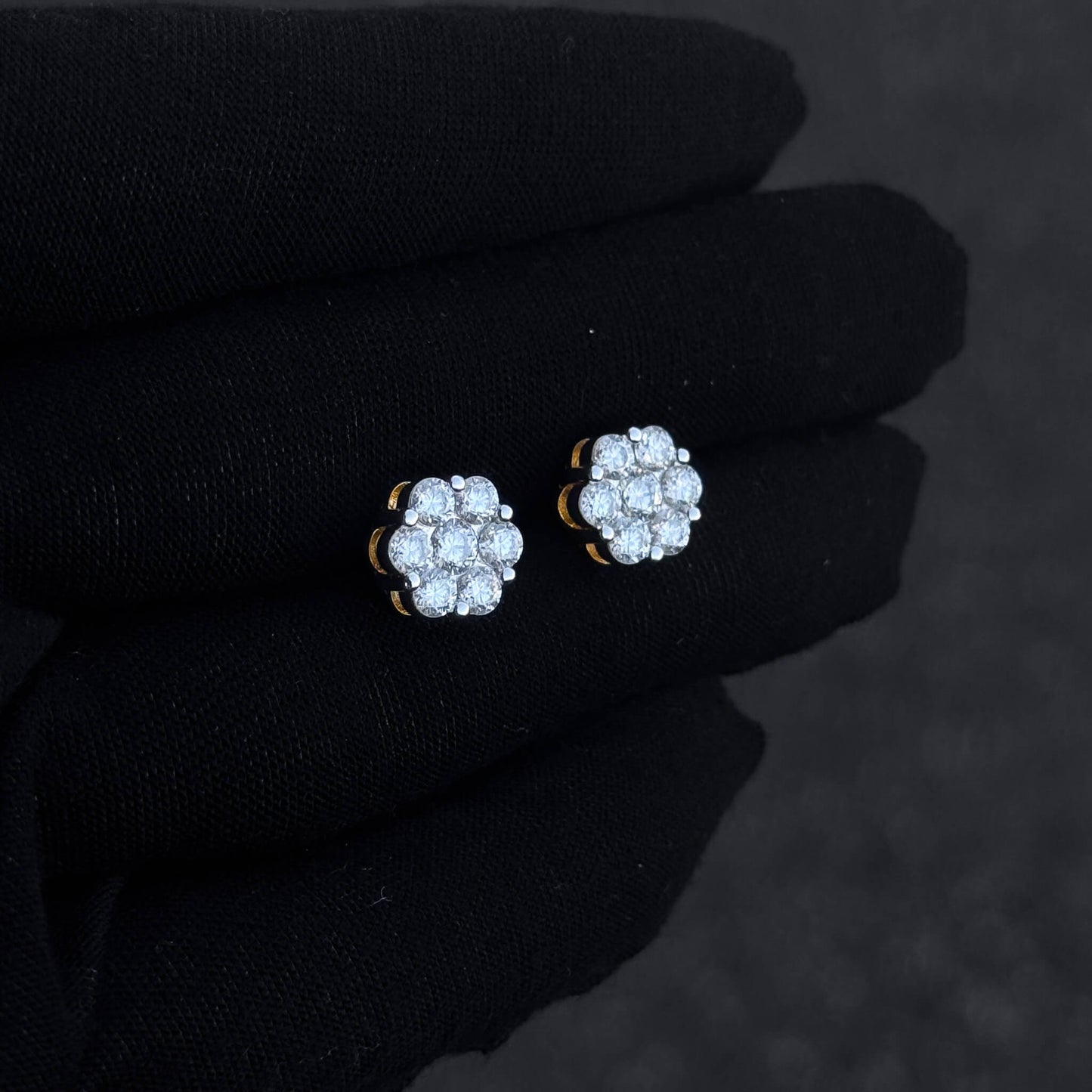 Small 10mm sterling silver moissanite cluster stud earrings with bright round diamonds on hand.