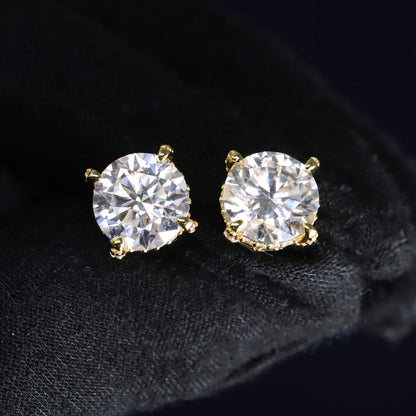 Gold stud earrings with clear gemstones on a black background