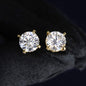 Gold stud earrings with clear gemstones on a black background