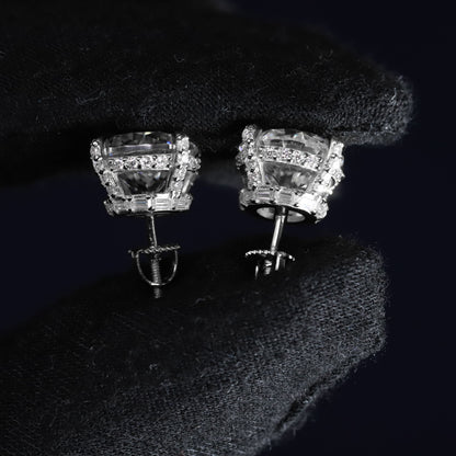 Pair of silver earrings with clear gemstones on a dark background