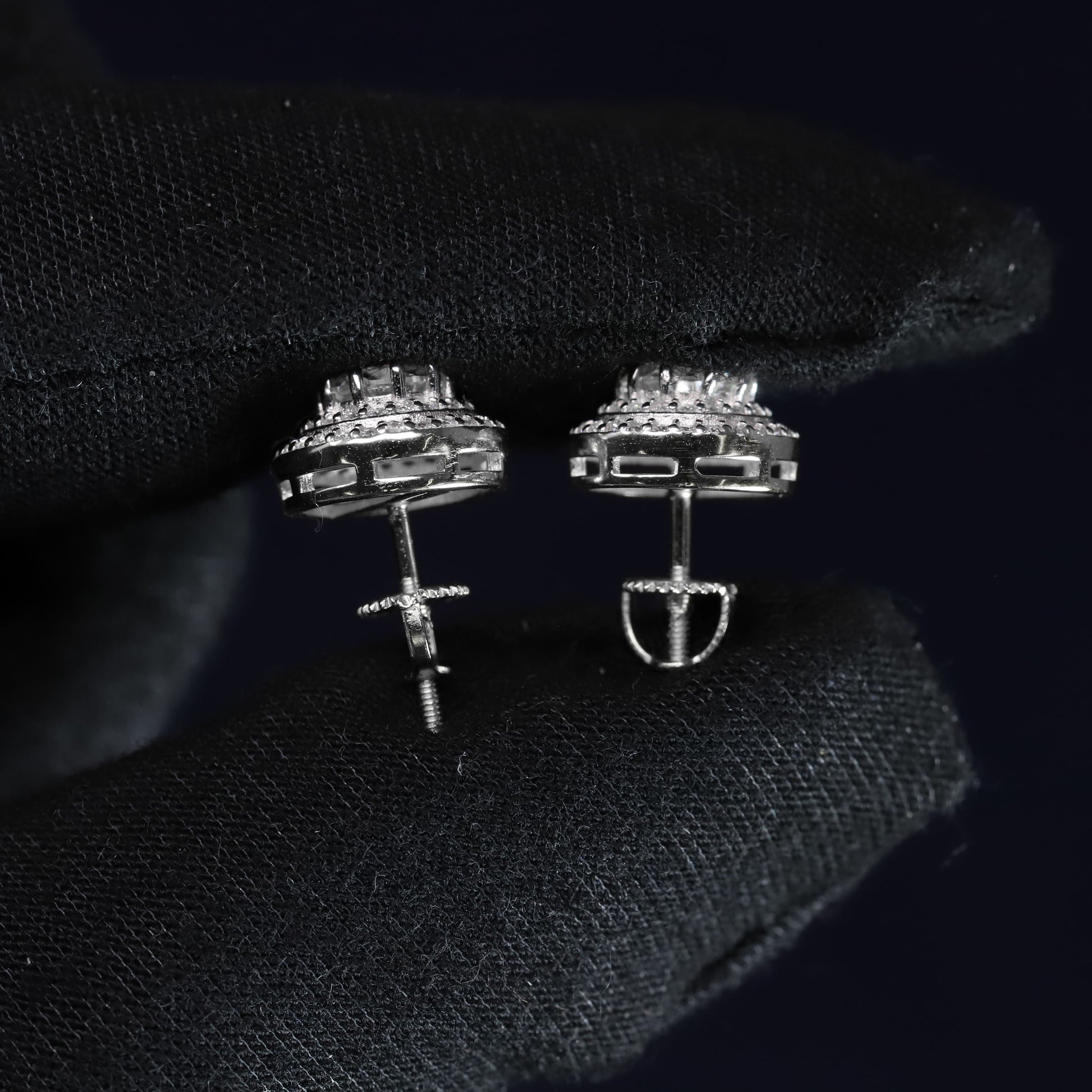Pair of silver earrings on a black textured surface