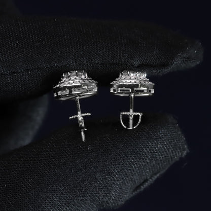 Pair of silver earrings on a black textured surface