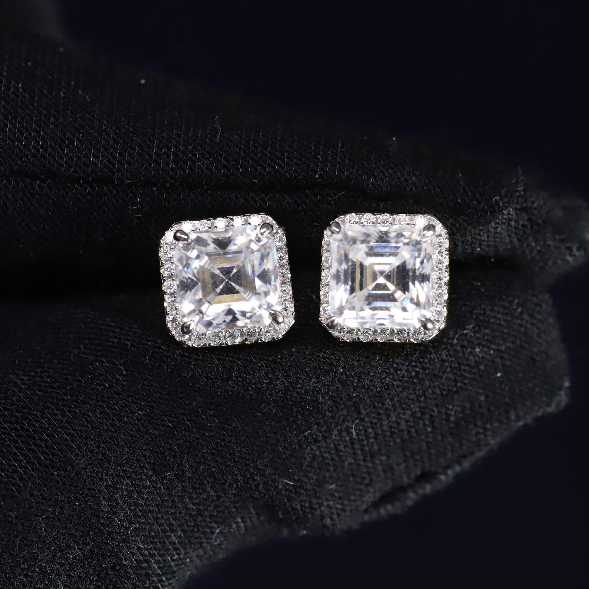 Square-cut diamond earrings on a black background