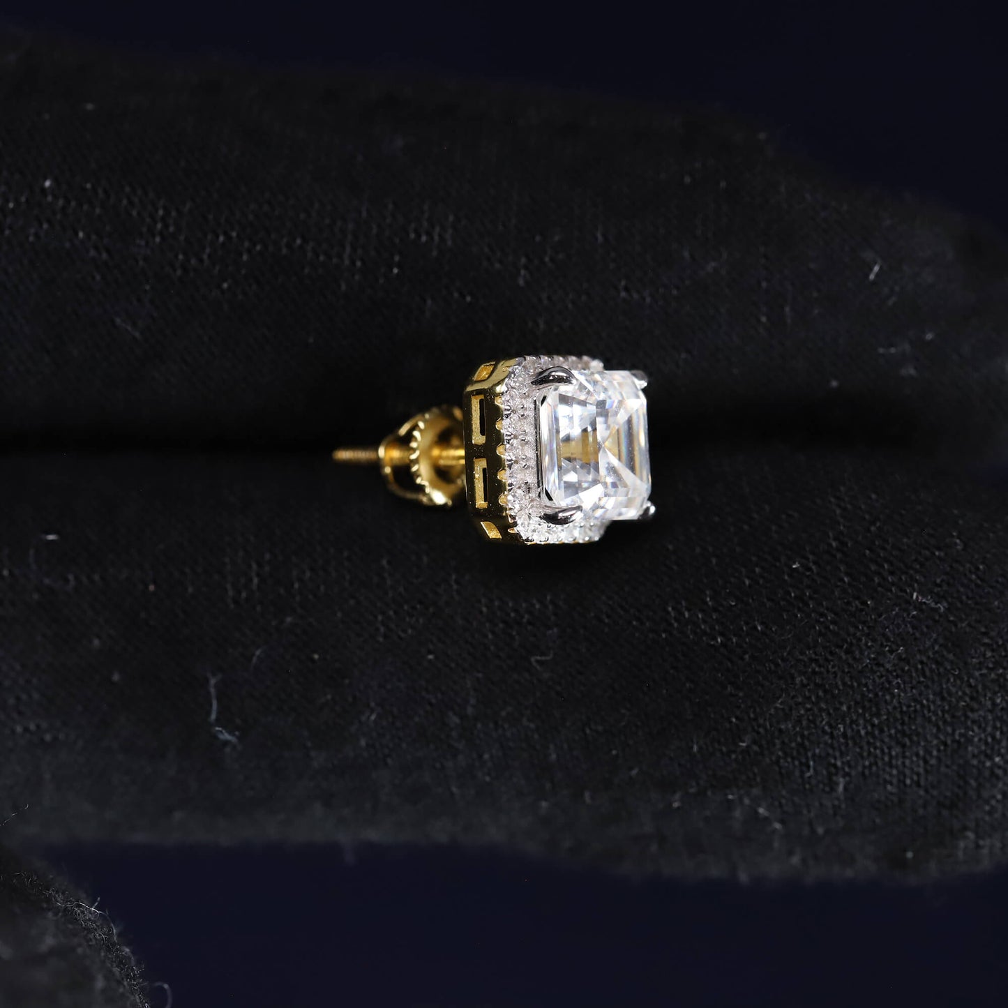 Gold and diamond earring on a black velvet background