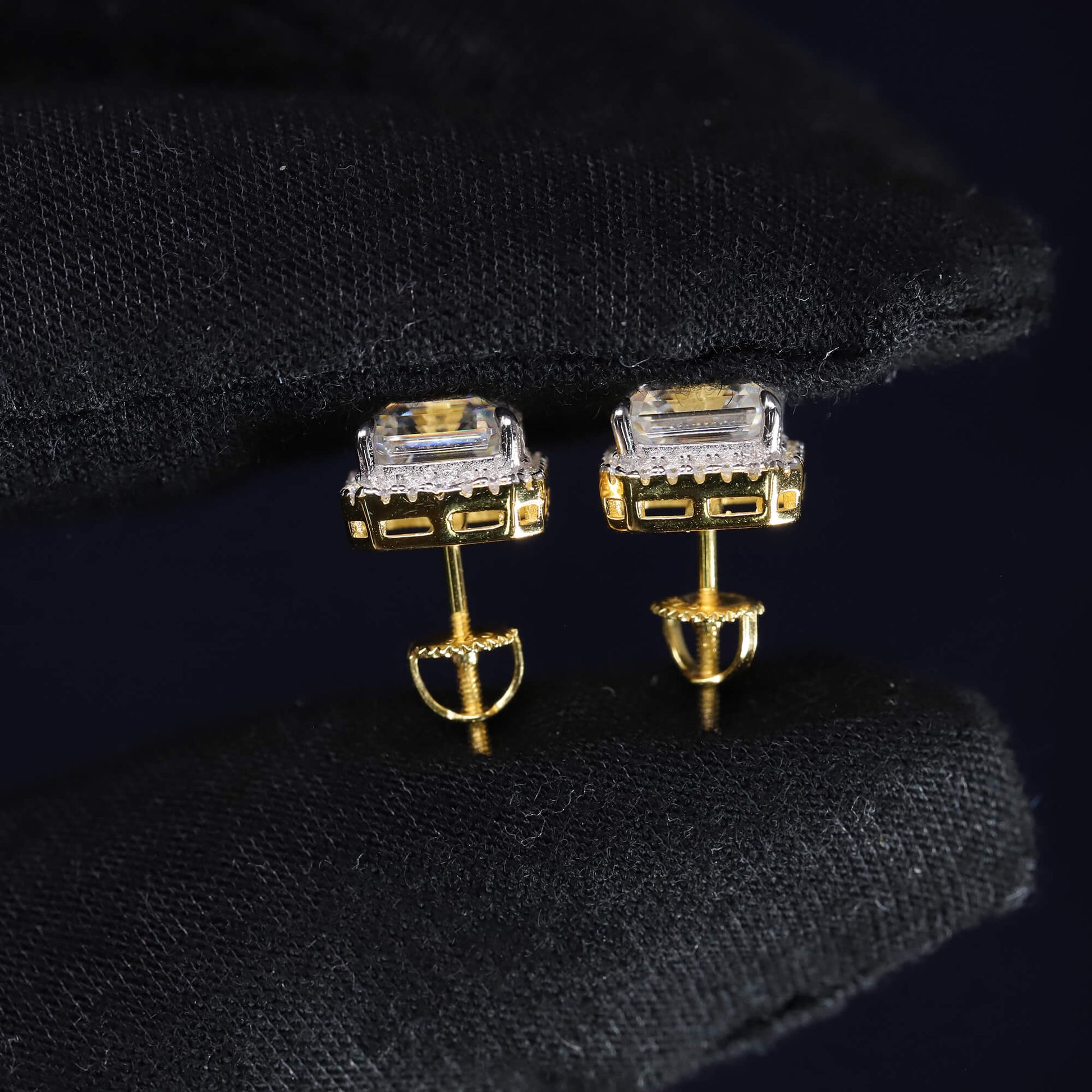 Gold earrings with gemstones on a black background