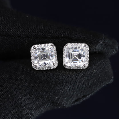 Pair of square-cut diamond earrings on a black background