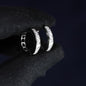 Silver hoop earrings with embedded stones on a black fabric background