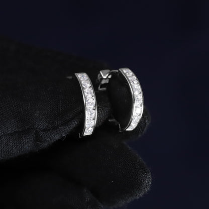 Silver hoop earrings with clear stones on a black background