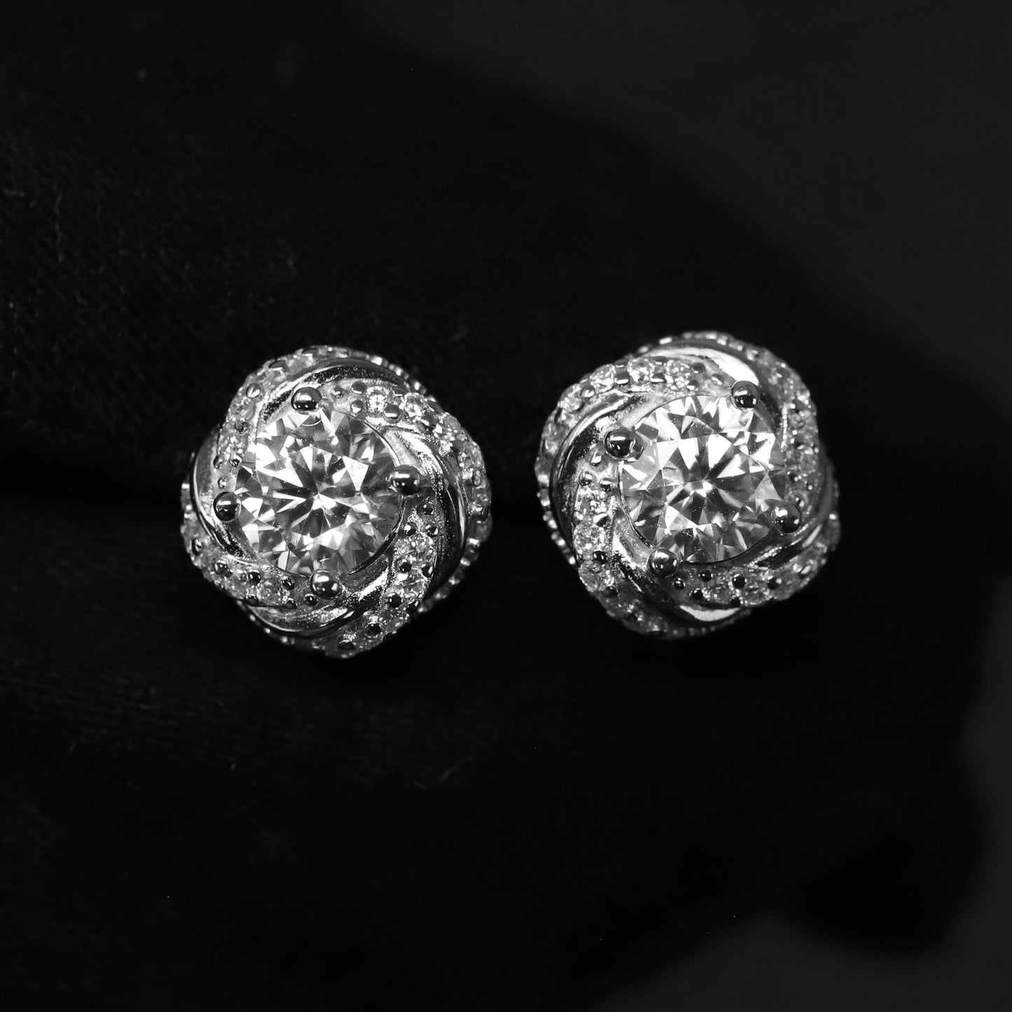 Pair of diamond stud earrings on a black background