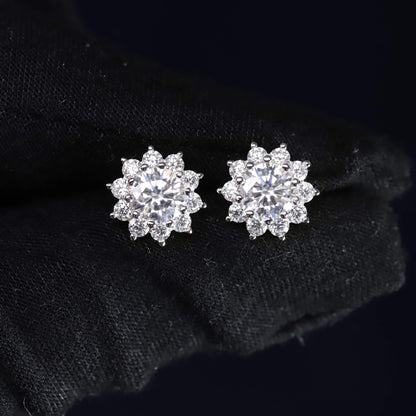 Pair of silver flower-shaped earrings on a black background