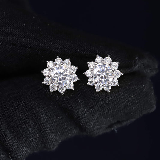 Pair of silver flower-shaped earrings on a black background