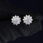 Pair of silver flower-shaped earrings on a black background