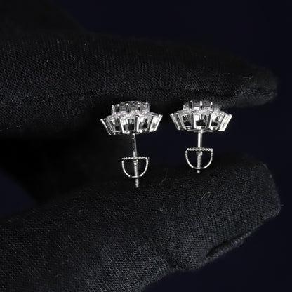 Pair of silver earrings with clear gemstones on a black background