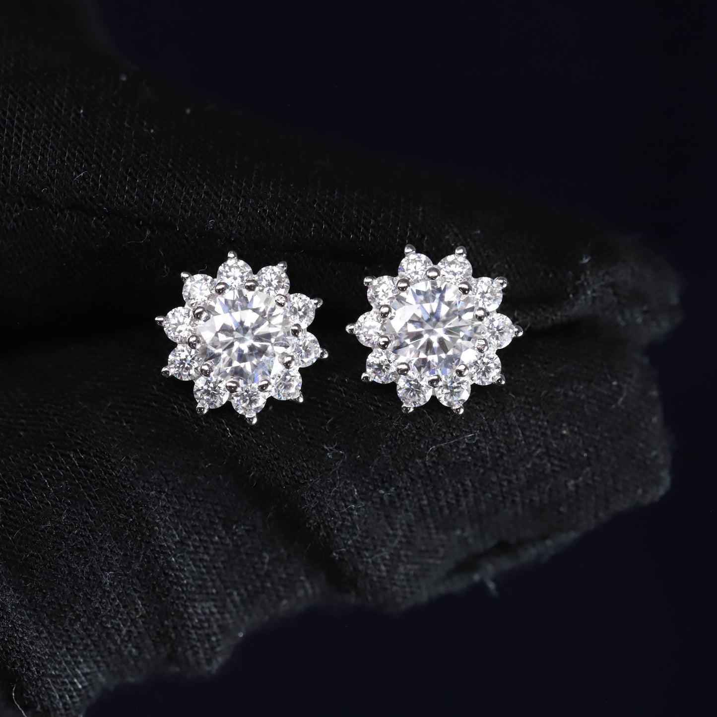 Pair of silver flower-shaped earrings on a black background