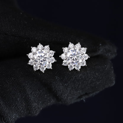 Pair of silver flower-shaped earrings on a black background