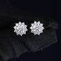 Pair of silver flower-shaped earrings on a black background