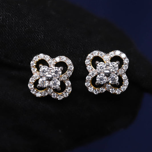 Butterfly-shaped earrings with clear gemstones on a dark background