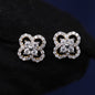 Butterfly-shaped earrings with clear gemstones on a dark background