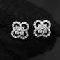 Pair of silver butterfly-shaped earrings with clear gemstones on a black background