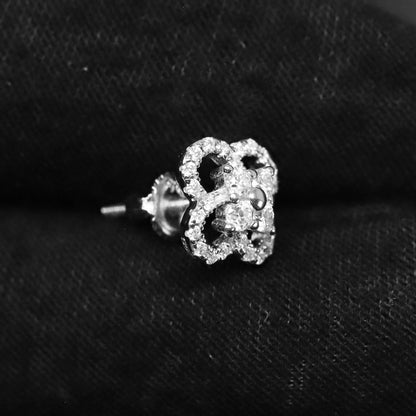 Silver crown-shaped earring on a black background