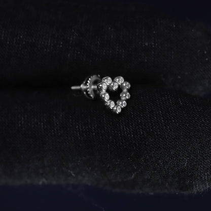 Heart-shaped earring with clear stones on a black velvet background