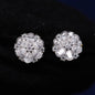 Pair of silver floral earrings with clear gemstones on a dark background