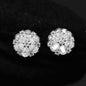 Pair of silver floral earrings with clear gemstones on a black background