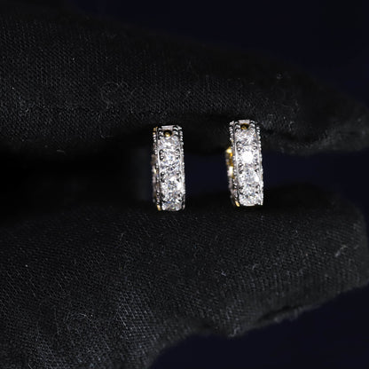 Pair of diamond hoop earrings on a black fabric background