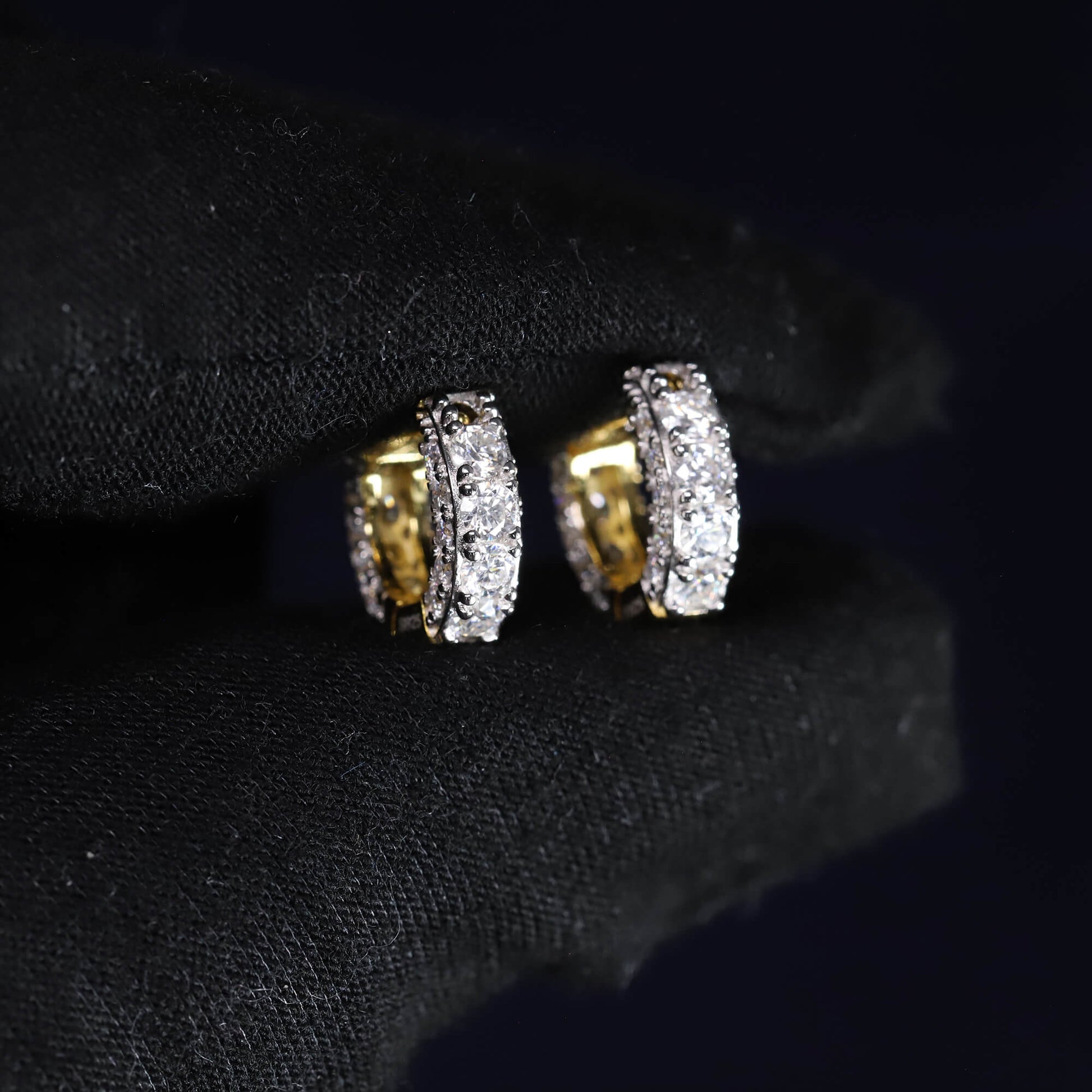 Pair of gold and diamond earrings on a black background
