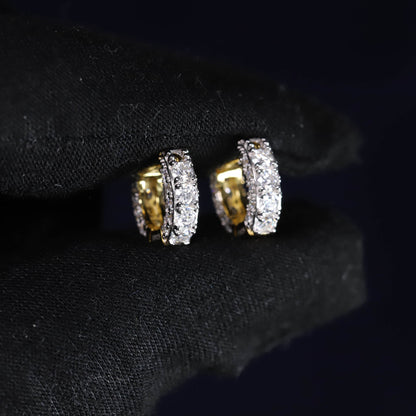 Pair of gold and diamond earrings on a black background