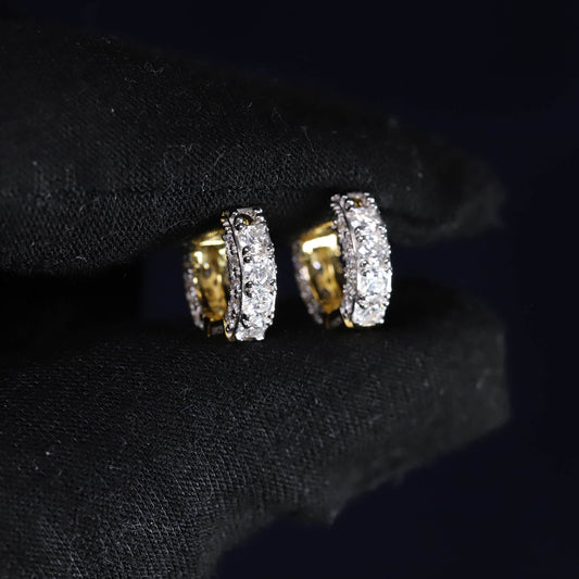 Pair of gold and diamond earrings on a black background