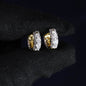 Pair of gold and diamond earrings on a black background