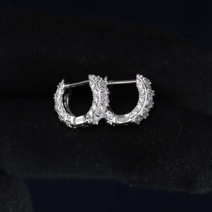 Gold hoop earrings with diamond accents on a black background