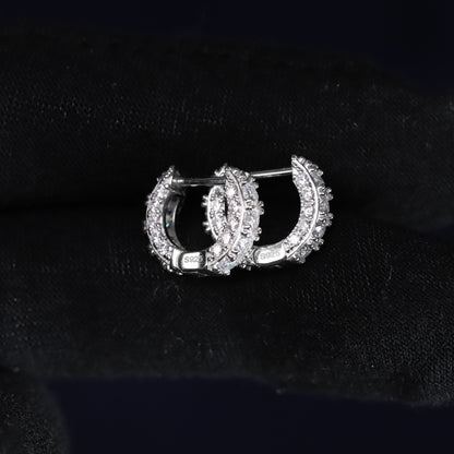 Pair of gold and diamond hoop earrings on a black background