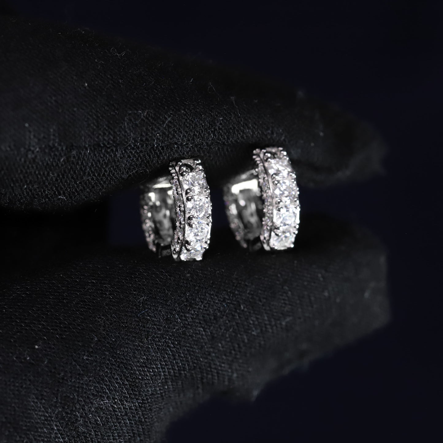 Silver earrings with gemstones on a black background