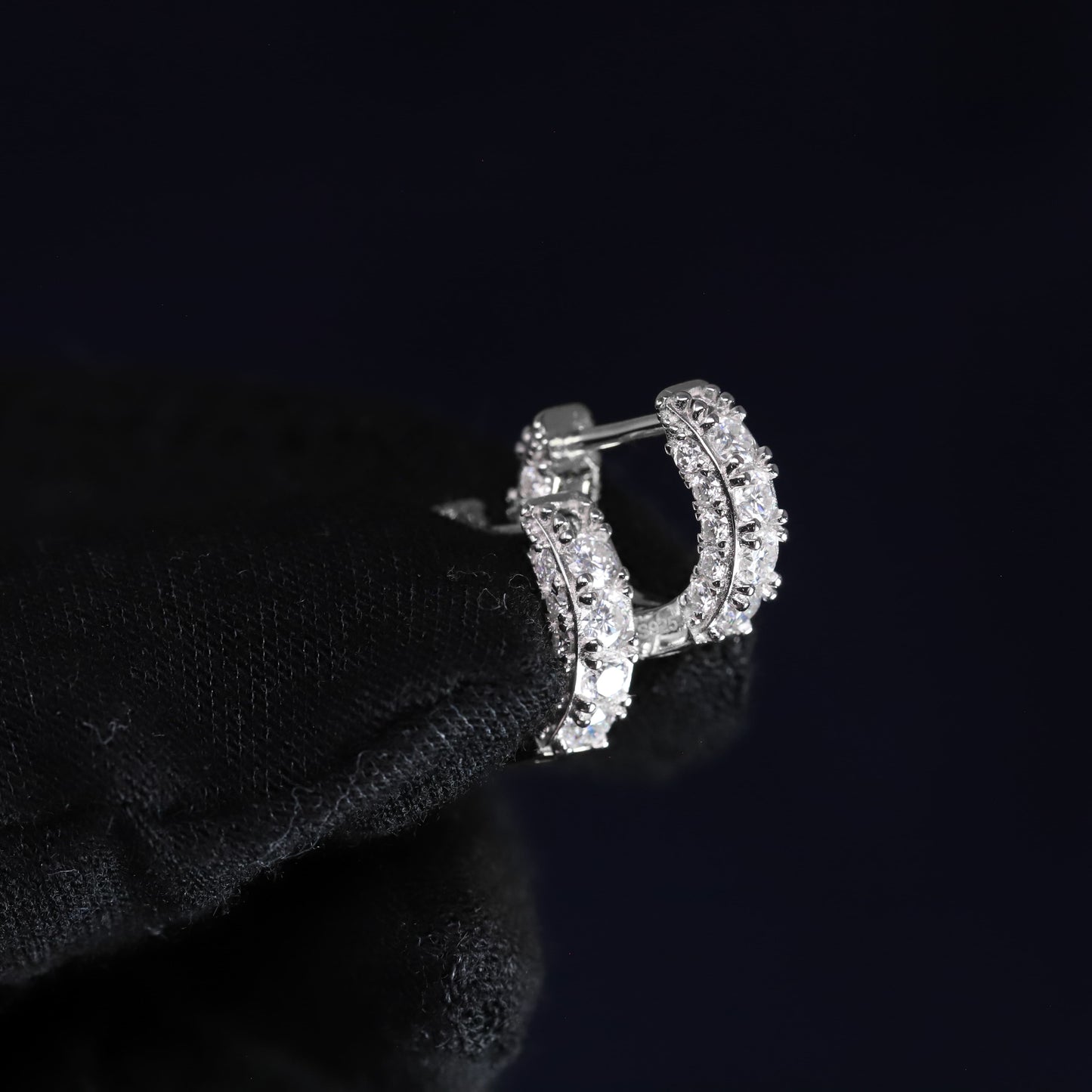 Silver letter 'D' earring on a black background