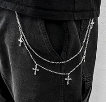 Layered chain necklace with cross pendants on a black outfit against a white background