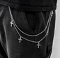Layered chain necklace with cross pendants on a black outfit against a white background