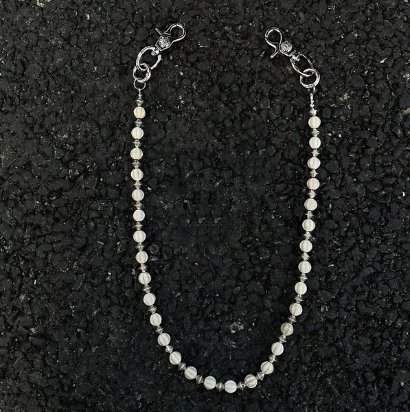 Beaded necklace on a textured black surface