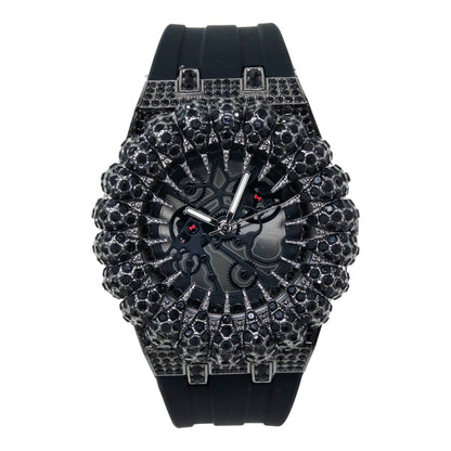 Black wristwatch with intricate design and gemstones on a white background